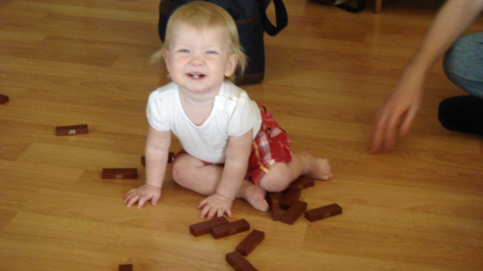 Emily playing on the floor with Jenga pieces