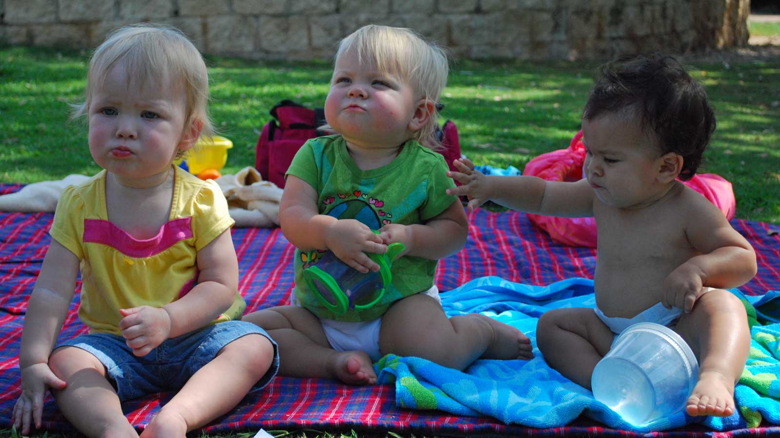 Emily, Jillian, and Aly enjoying snacks on a picnic blanket