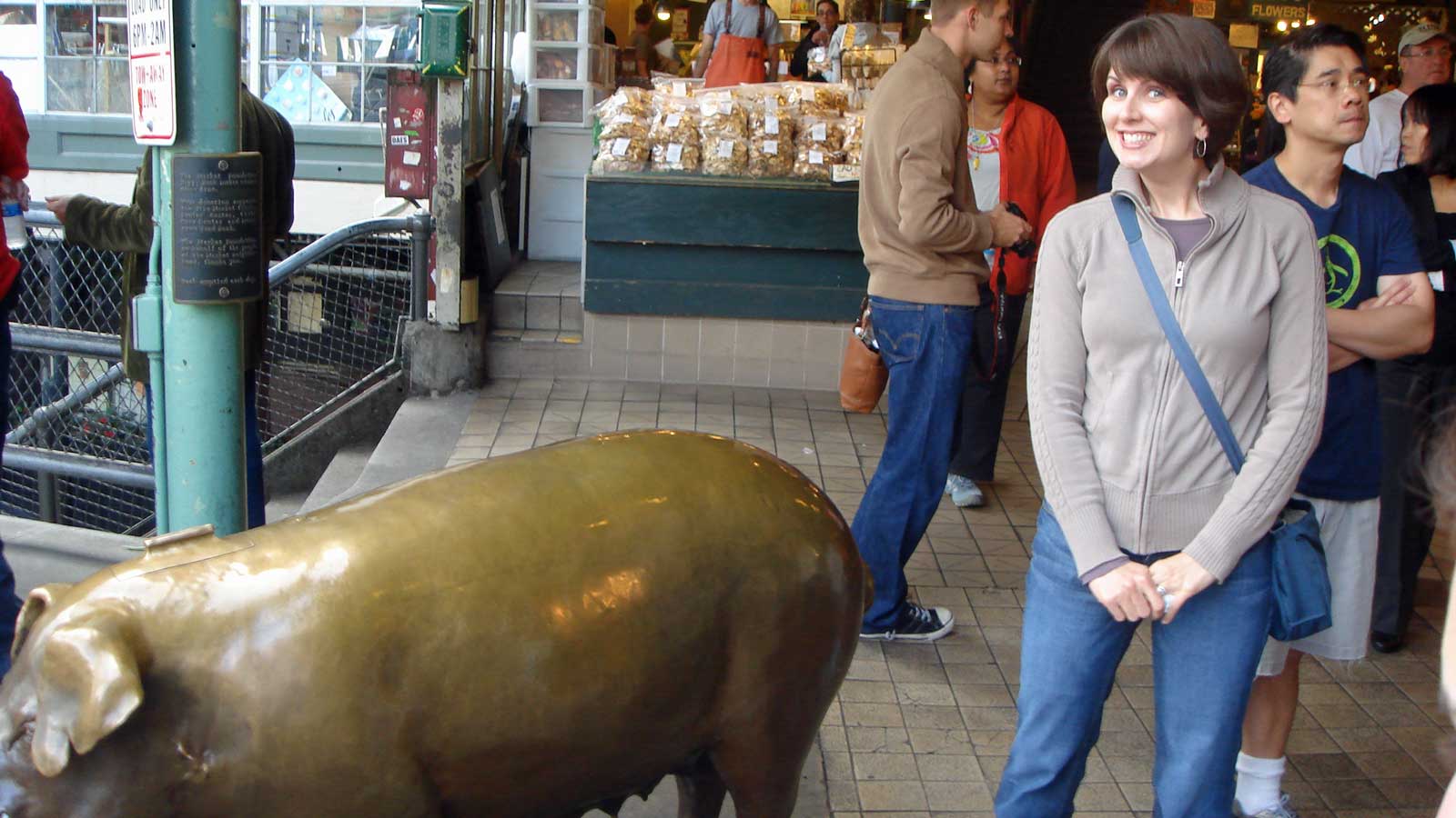 Rebecca standing next to a large bronze pig