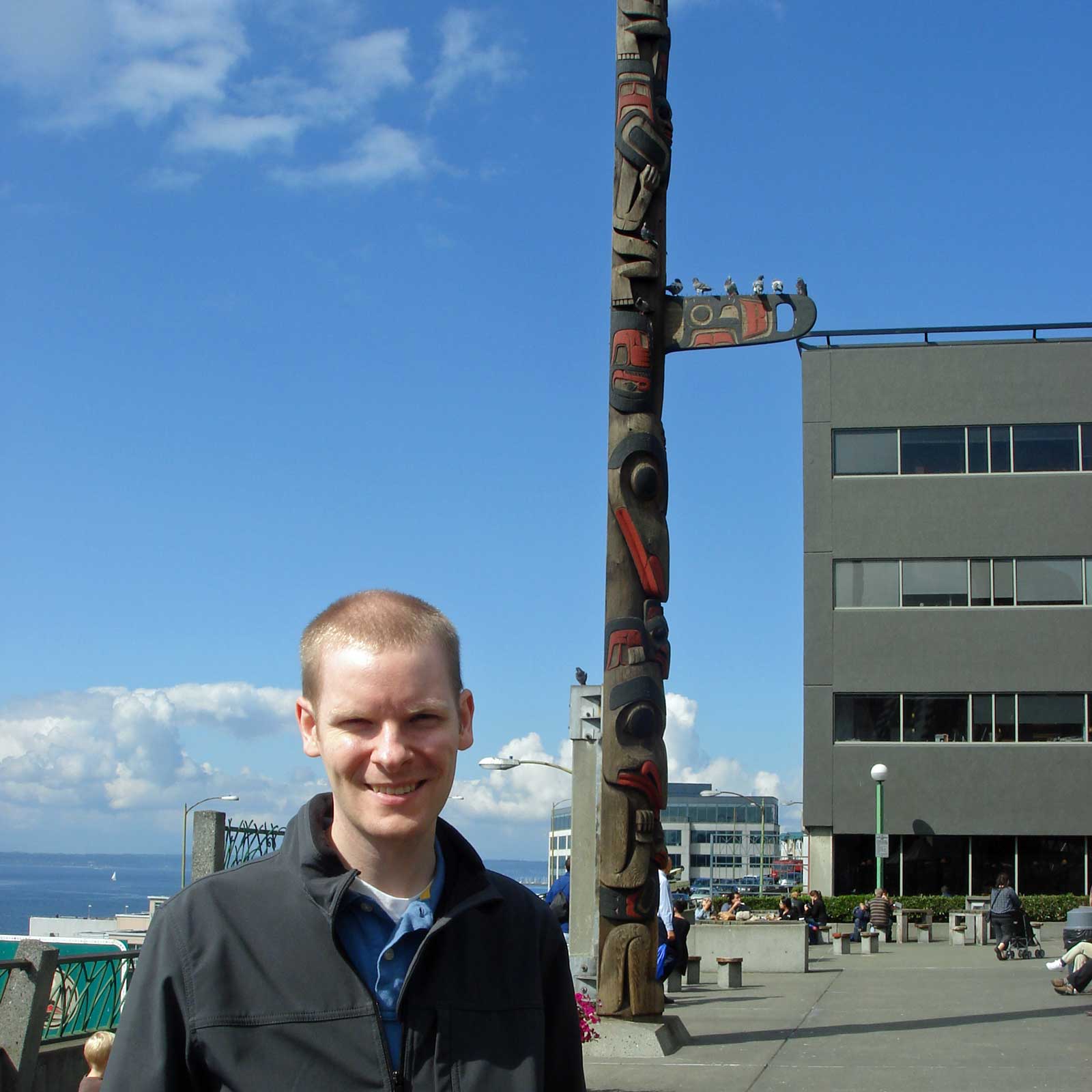 William standing in front of a tall totem pole