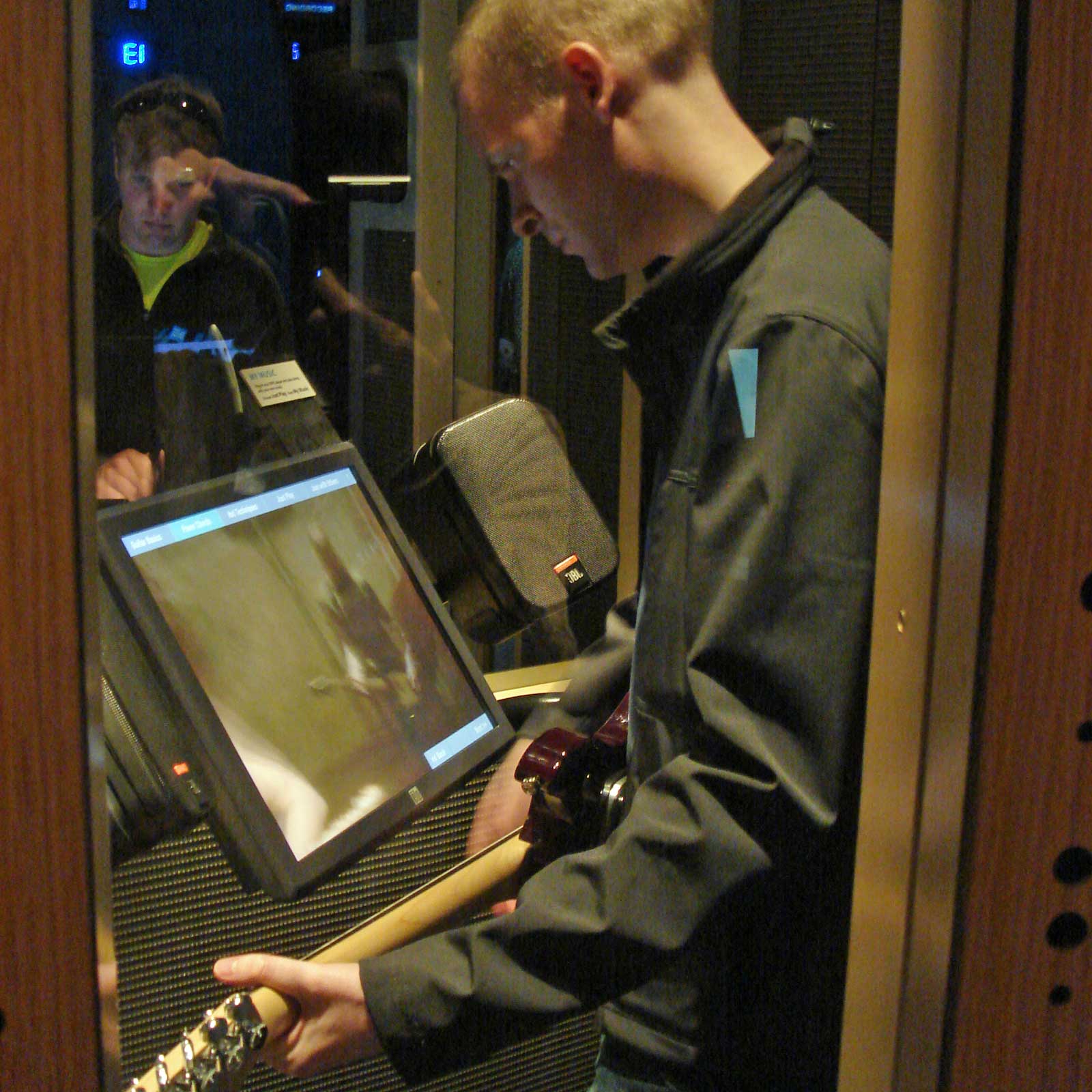 William playing guitar in a sound booth
