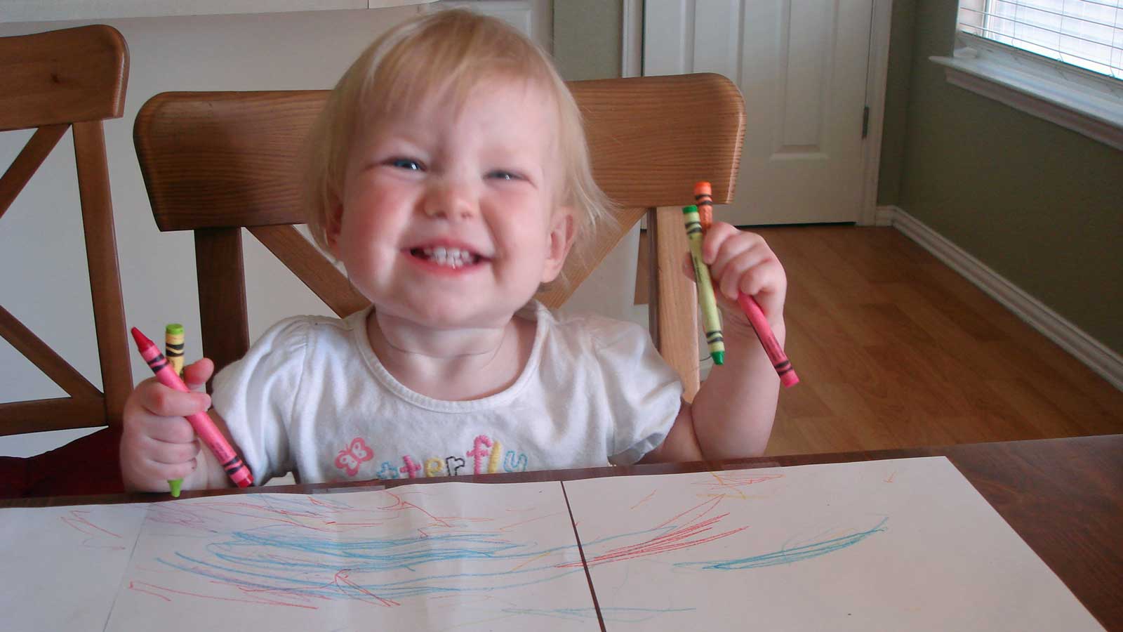 Emily coloring on paper with crayons